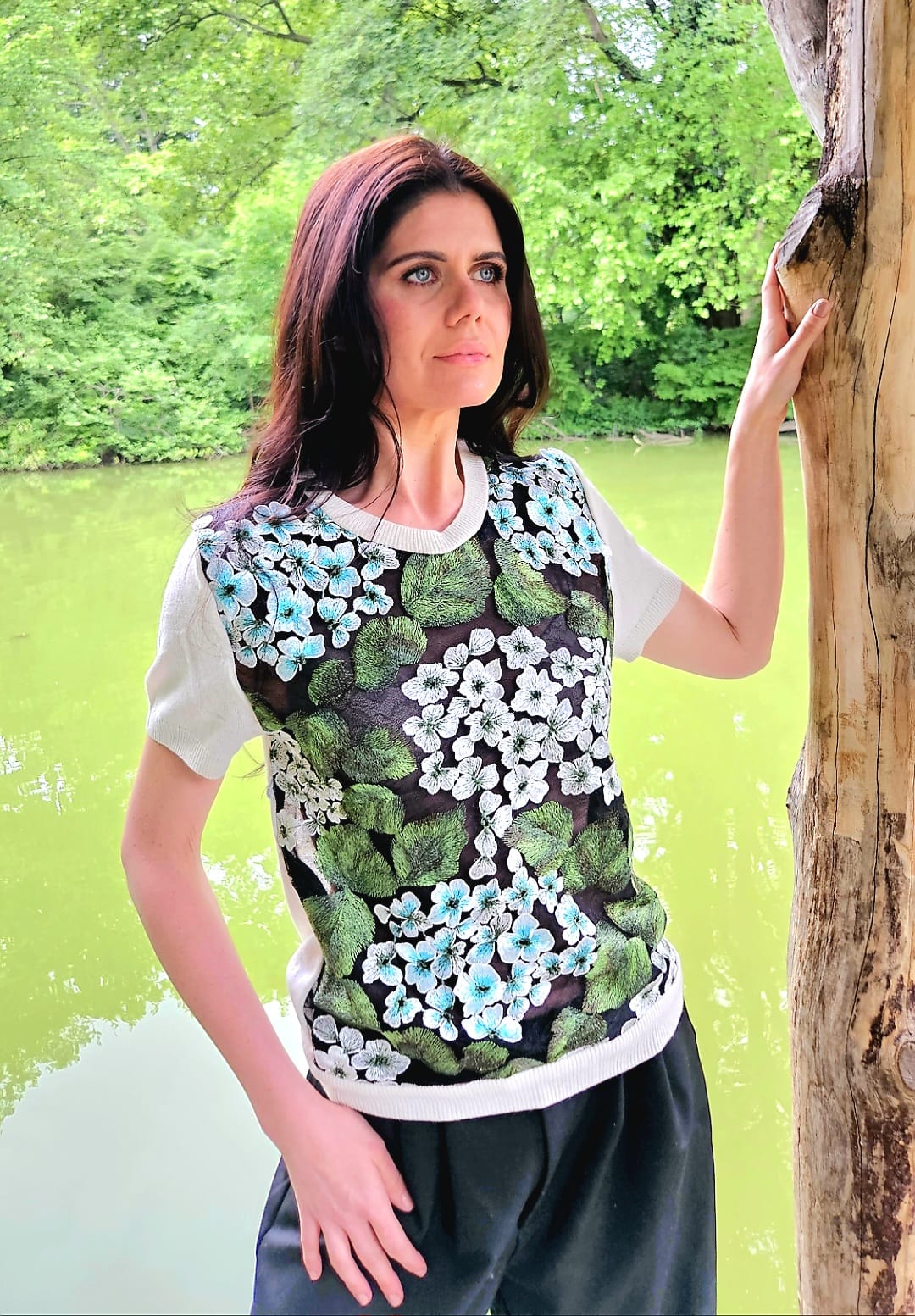 MEDIUM IVORY 100% CASHMERE SHORT SLEEVE T-SHIRT WITH FRONT INSERT OF EMBROIDERED TINY TURQUOISE & LILY WHITE FLOWERS WITH GREEN LEAVES PLANTED ON MYSTERIOUS BLACK LACE GARDEN